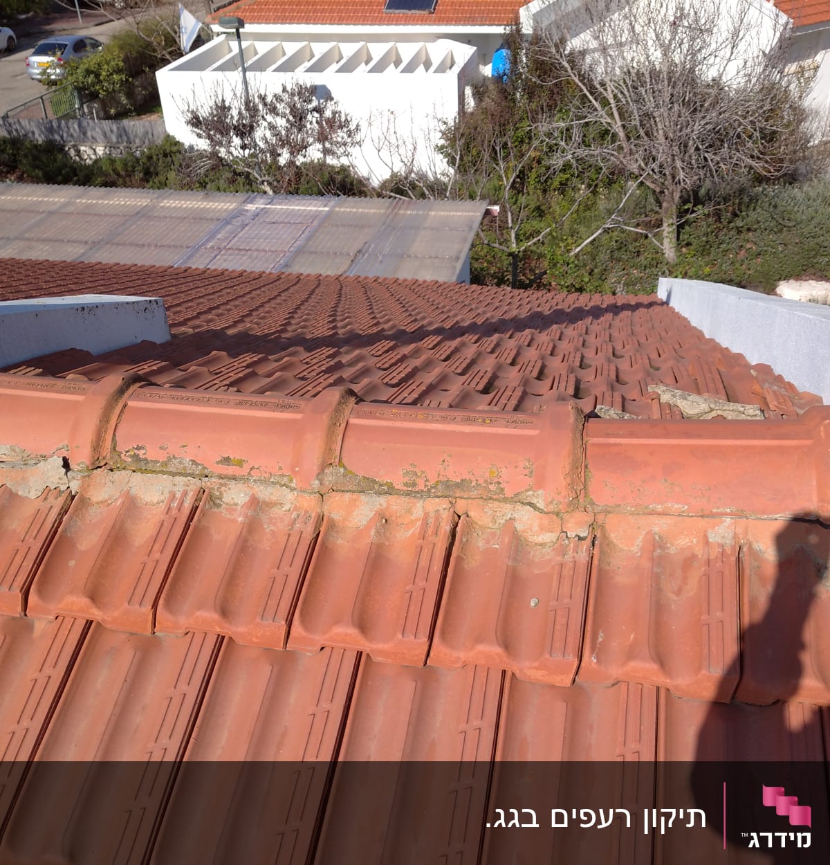 רעפים כתומים על גג עם סימני בלאי ותיקונים